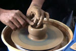 Pottery throwing a cylinder on wheel